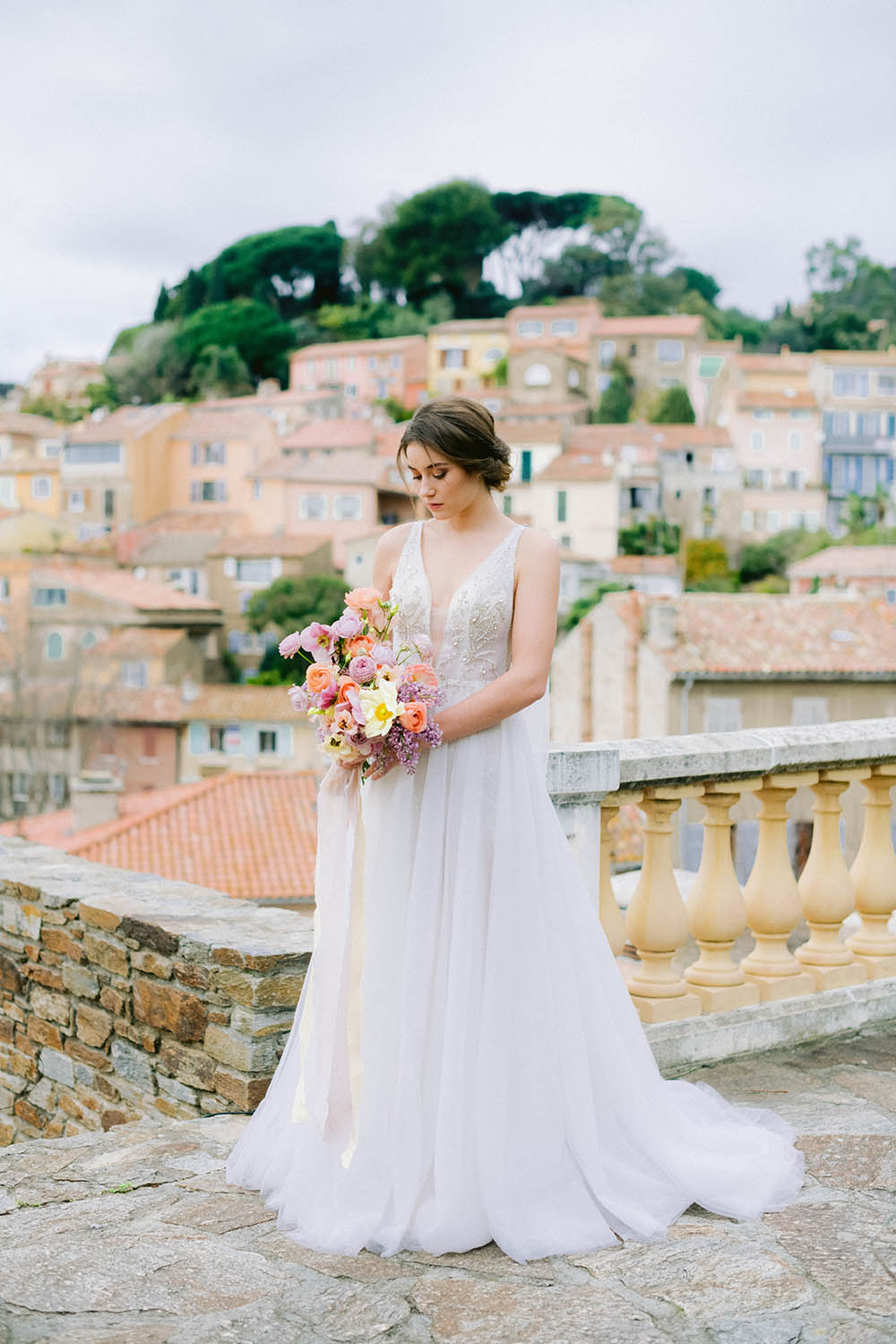 la mariée se trouve à bormes les mimosas et tient dans sa main un bouquet